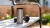 Afbeelding van een herbruikbare koffiebeker op een bankje buiten.