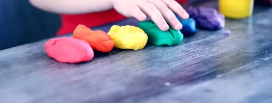Child playing with different colours of clay