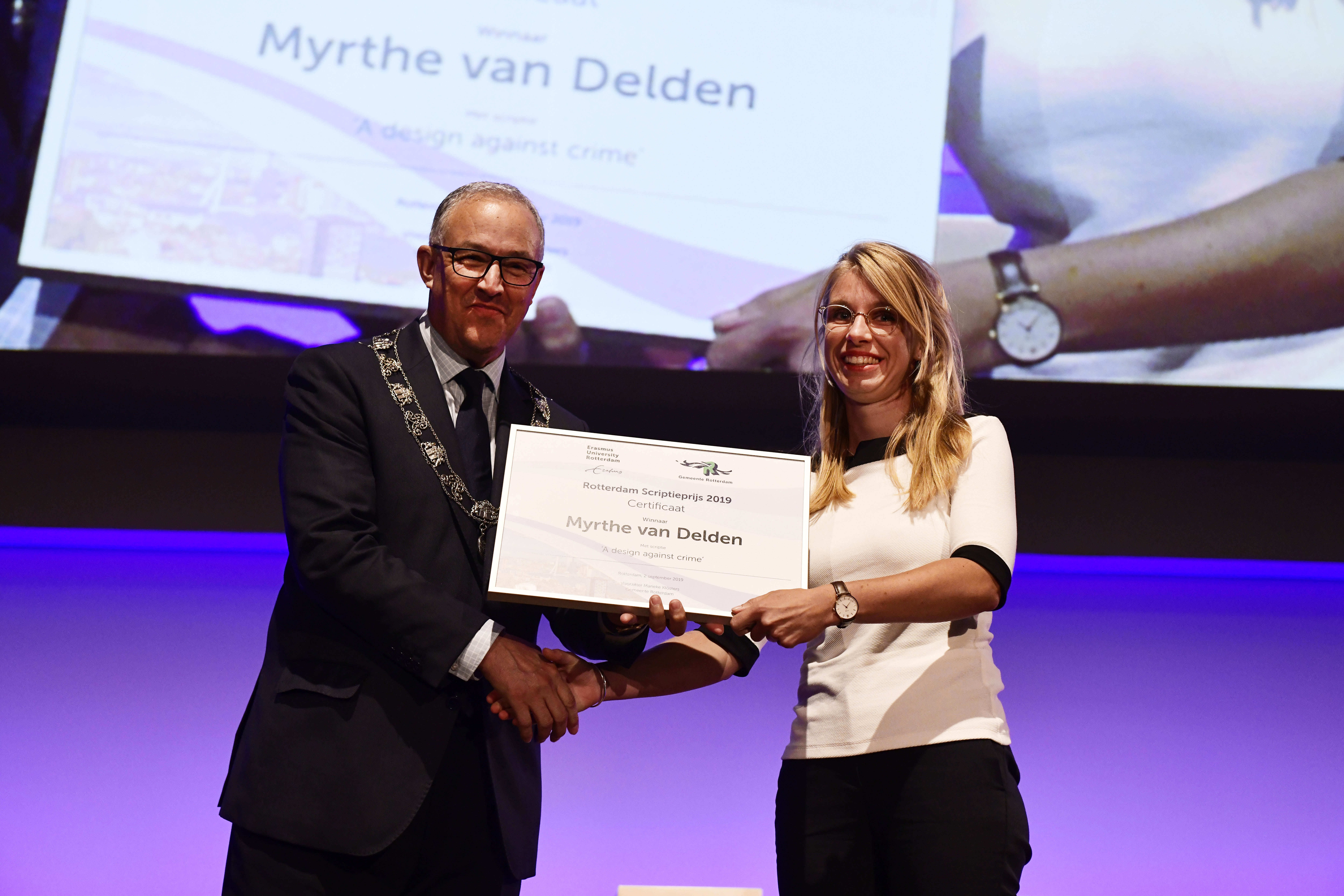 Ahmed Aboutaleb overhandigt Rotterdam Scriptieprijs aan Myrthe van Delden tijdens OAJ 2019-2020