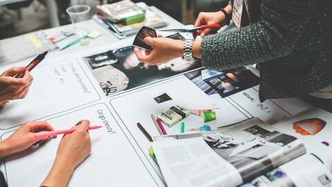 People organizing snippets of articles for a collage