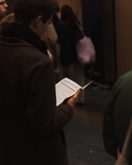 Prospective student looks in information booklet during Master Open Day.