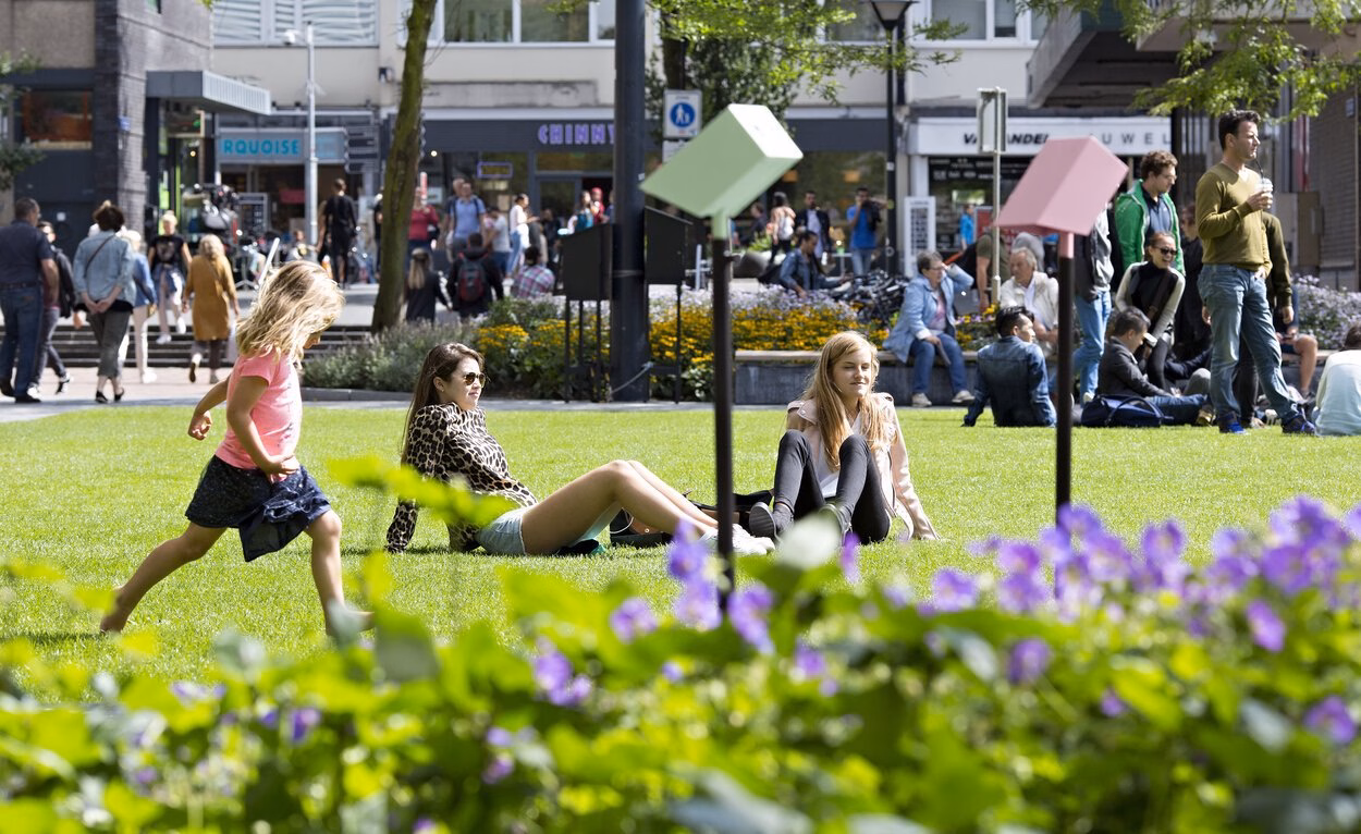 People sit in the park near the Laurenskerk church in Rotterdam.