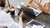 2 people sitting at a table with a laptop, smartphone and coffee
