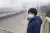 Jongen met mondkapje bij snelweg in Aziatische stad