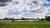 Skyline Rotterdam vanaf Kralingse Bos met wolkenlucht, water en gras