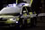In the background a blurred English police car and in the foreground police tape with the words 'Police line do not cross'