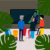 Lecturers in front of a screen and tropical leaves