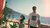 Two people standing with a beach as the background