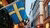 Street view between commercial building showing a hoist Swedish flag