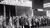 People standing outside on the street in line for the unemployed line to receive food