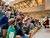 Children in stands with headphones on and hands in the air to ask questions