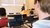 Man watching a lecture while looking at laptop full of stock information