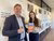 Philip Hans Franses presents his book to Carlijn Smeets in front of a wall in the E-building