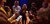 People standing in a circle and looking at each other while holding smarthone