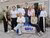 Group of students and employees standing in front of a row of houses