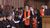 Woman in black gown and red sash with black top head and rolled up paper in a cathedral like space
