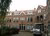 Red-brick terraced houses in the Bloemhof neighbourhood of Rotterdam, with arched balconies surrounding a courtyard where cars are parked.