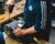Photograph of hands using a power drill on a cylindrical motor housing on a workbench