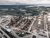 Aerial view of coastal oil refinery complex with storage tanks, pipelines, and smokestacks
