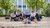 Students sitting outside on the stairs on campus in summer.