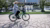Person riding a bicycle on the campus Woudestein near the pond