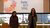 Two women standing in front of a presentation screen