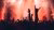 Pop concert: dark silhouettes, red colors, mist and hands in the air