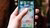 A hand holding a smartphone with music apps such as Spotify
