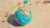 miniature globe laying on the beath with flags pinned into it