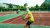 Person seen from behind in yellow T-shirt with tennis racket on tennis court.