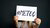 Woman with red nail polish holding a sign that says '#metoo'