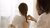 A person braiding the hair of a child