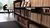 Low metal bookshelves filled with books from the Leeskabinet. Students are reading in the background.