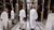 People in white coats looking at art