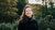 Headshot of Dr Ana Vasques, smiling into the camera, standing in front of trees