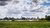 Skyline Rotterdam vanaf Kralingse Bos met wolkenlucht, water en gras