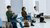 three people sitting in chairs in a row and listening