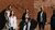 A diverse group of people in front of a wall