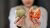 Women holding apple and donut in front of camera