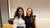 Two women are standing in a lecture hall and are posing for the picture.
