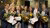 7 alumni met bossen bloemen en een certificaat voor het beeld van Erasmus in Erasmus Building