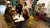 Five students discussing around a table with a popcorn stand in the background