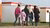 Three women with three children from which two are walking and one is being held in the arms of one of the women