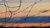 A close-up of barbed wire with an orange sunset in the background.