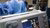 Doctors are working in an operating room in blue coats.