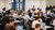 Students are taking an exam behind their laptop in an exam hall.