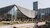 Students and staff sit outside in the sun at Erasmus Pavilion.