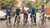 five male cyclists posing, dressed in 80s clothes