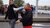 Housing activist Mustapha Eaisaouiyen walks through the city while talking through a megaphone.