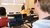 Man watching a lecture while looking at laptop full of stock information